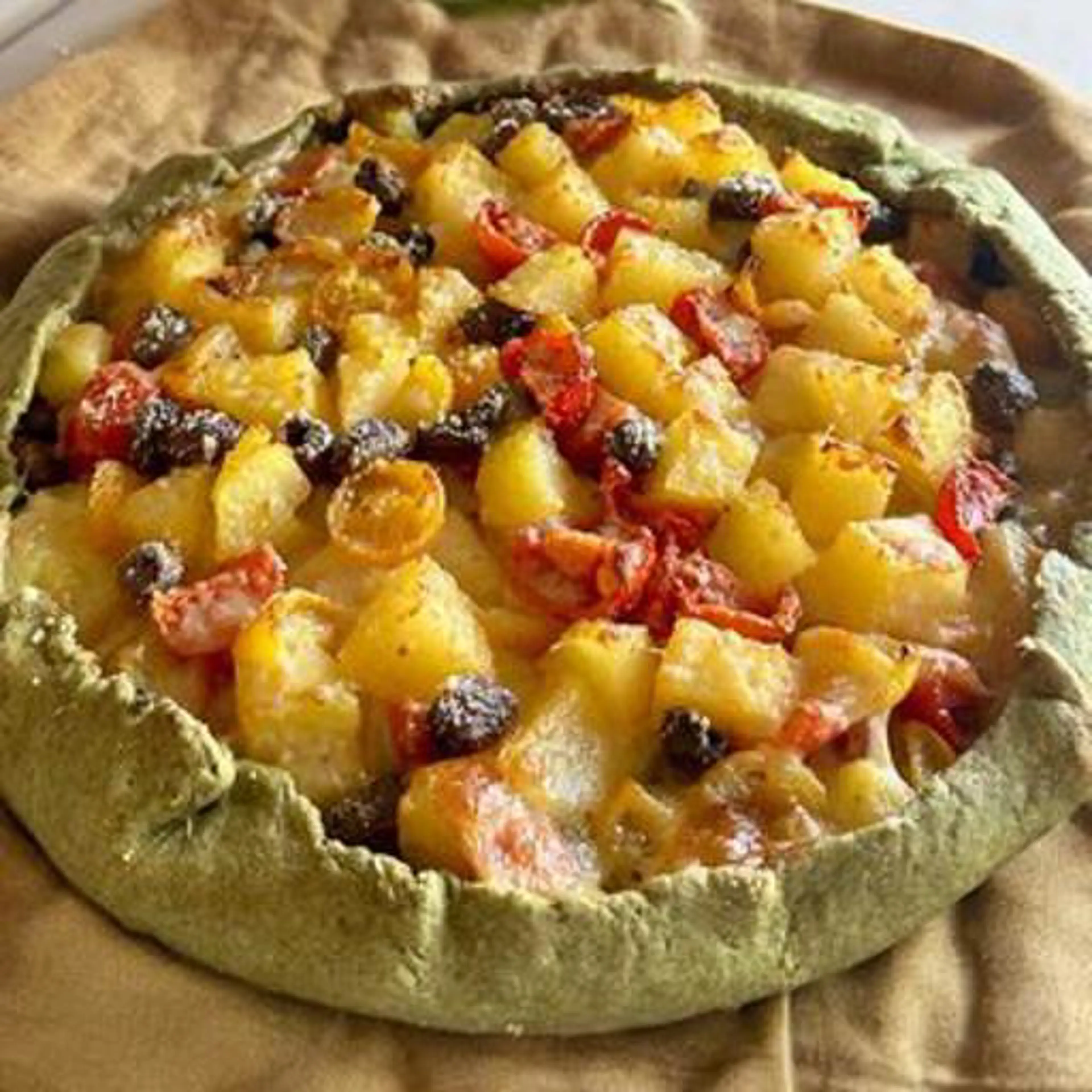 Savory pie with potatoes, cherry tomatoes and olives