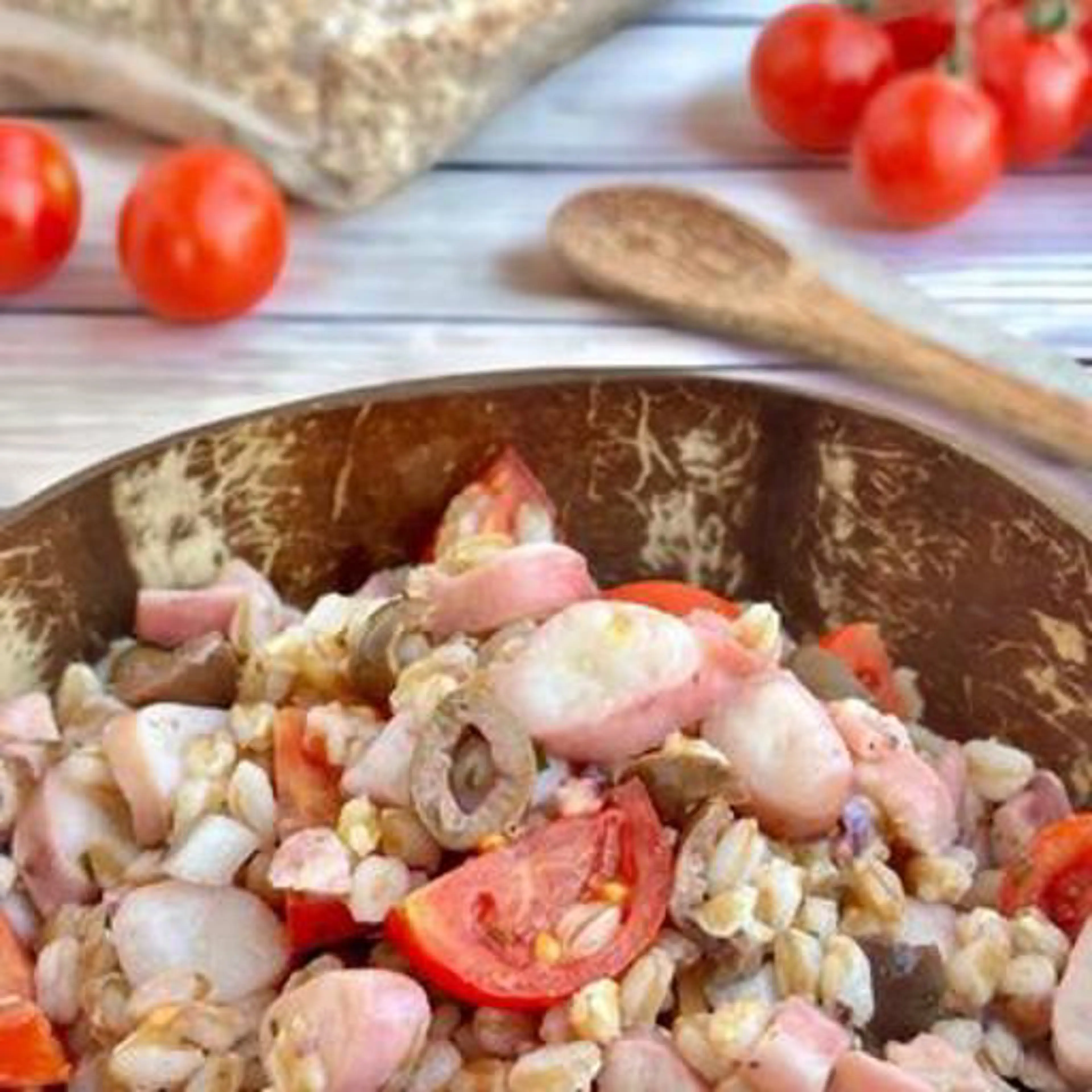 Farro salad with squid tentacles, cherry tomatoes and Taggiasca olives